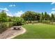 Expansive backyard featuring lush lawn, mature landscaping, and a serene lake view, all enclosed by a fence at 16531 Kendleshire Ter, Lakewood Ranch, FL 34202