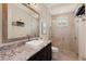 Well-lit bathroom with modern vanity, granite countertop, sleek mirror, and glass enclosed shower at 16531 Kendleshire Ter, Lakewood Ranch, FL 34202