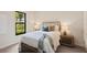 Cozy bedroom with a comfortable bed, soft lighting, and a large window offering natural light at 16531 Kendleshire Ter, Lakewood Ranch, FL 34202