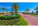 Inviting community entrance featuring a tiered fountain, lush landscaping, and brick-paved road at 16531 Kendleshire Ter, Lakewood Ranch, FL 34202