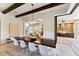 Elegant dining room with a long table, modern chandelier, and sliding doors to the outdoor kitchen at 16531 Kendleshire Ter, Lakewood Ranch, FL 34202