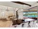An open floor plan features a dining table with exposed wood beams and access to the lanai at 16531 Kendleshire Ter, Lakewood Ranch, FL 34202