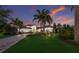 Elegant Mediterranean-style home with lush landscaping, a brick driveway, and a picturesque sunset backdrop at 16531 Kendleshire Ter, Lakewood Ranch, FL 34202
