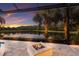 Enjoy lake views from the outdoor fire pit area, surrounded by lush landscaping and a screened enclosure at 16531 Kendleshire Ter, Lakewood Ranch, FL 34202
