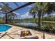 Outdoor fire pit and lake views, enhanced by the screened enclosure for comfortable enjoyment at 16531 Kendleshire Ter, Lakewood Ranch, FL 34202
