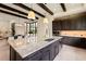 Open-concept kitchen features a large island with a granite countertop and dark wood cabinetry at 16531 Kendleshire Ter, Lakewood Ranch, FL 34202