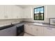 Functional laundry room featuring front-load washer and dryer and storage at 16531 Kendleshire Ter, Lakewood Ranch, FL 34202