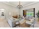 A bright living room features a chandelier, tile floors, and sliding doors to a covered lanai at 16531 Kendleshire Ter, Lakewood Ranch, FL 34202