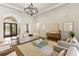 Elegant living room featuring a sophisticated chandelier, arched doorway, and tasteful decor at 16531 Kendleshire Ter, Lakewood Ranch, FL 34202