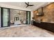 Covered patio featuring an outdoor kitchen, grill, and seamless transition to the living room through sliding glass doors at 16531 Kendleshire Ter, Lakewood Ranch, FL 34202