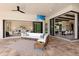 Stylish patio with comfortable seating, outdoor TV, and seamless transition to indoor living spaces through sliding glass doors at 16531 Kendleshire Ter, Lakewood Ranch, FL 34202