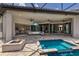 Inviting covered patio with pool, fire pit, and seamless transition to indoor living spaces through sliding glass doors at 16531 Kendleshire Ter, Lakewood Ranch, FL 34202