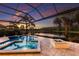 Relaxing pool and spa area with a fire pit, offering stunning views of the tranquil lake and sunset at 16531 Kendleshire Ter, Lakewood Ranch, FL 34202