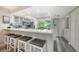 The well-lit open kitchen has white cabinets, a breakfast bar, stainless steel appliances, and a great view of the outdoors at 1740 Alderman St # 7, Sarasota, FL 34236