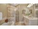 Elegant bathroom featuring a soaking tub, glass-enclosed shower, and a double vanity with decorative accents at 1771 Ringling Blvd # 1206, Sarasota, FL 34236
