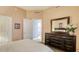 Comfortable bedroom featuring a large dresser, mirror, and convenient access to the adjacent bathroom and closet at 1771 Ringling Blvd # 1206, Sarasota, FL 34236