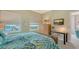 Well-lit bedroom showcasing a woven headboard bed, modern desk, and stunning city views from the windows at 1771 Ringling Blvd # 1206, Sarasota, FL 34236