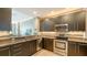 Kitchen area featuring granite countertops, stainless steel appliances, and dark wood cabinetry at 1771 Ringling Blvd # 1206, Sarasota, FL 34236