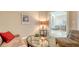 Open living room area with comfortable seating, a modern lamp, and a glimpse of the dining area beyond at 1771 Ringling Blvd # 1206, Sarasota, FL 34236