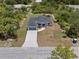 This aerial view showcases the home, driveway, lawn, new roof, and mature trees at 19185 Sherbrooke Ave, Port Charlotte, FL 33954