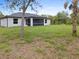 A view of the home's back exterior and yard which includes a patio and lush grass at 19185 Sherbrooke Ave, Port Charlotte, FL 33954