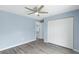 An ample bedroom with grey wood-look tile floors, a ceiling fan, and a spacious closet at 19185 Sherbrooke Ave, Port Charlotte, FL 33954