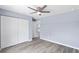 Spacious bedroom with hard surface flooring, ceiling fan, and large closet with white doors at 19185 Sherbrooke Ave, Port Charlotte, FL 33954