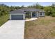 Charming one-story home featuring a large driveway, a two-car garage, and a well-maintained yard at 19185 Sherbrooke Ave, Port Charlotte, FL 33954