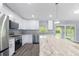 Well-lit kitchen boasting granite countertops, stainless steel appliances, and white cabinets at 19185 Sherbrooke Ave, Port Charlotte, FL 33954