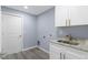 Well-lit laundry room with stylish tile flooring, modern cabinetry, and a granite countertop at 19185 Sherbrooke Ave, Port Charlotte, FL 33954