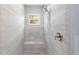 Shower with tiled walls and bench seating plus a showerhead and window overlooking the outdoors at 19185 Sherbrooke Ave, Port Charlotte, FL 33954