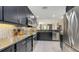 This kitchen showcases dark cabinets, granite countertops, stainless steel appliances, and flows into the dining area at 1921 Monte Carlo Dr # 302, Sarasota, FL 34231