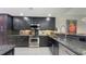 This kitchen features dark cabinets, granite countertops, stainless steel appliances, and a tile backsplash at 1921 Monte Carlo Dr # 302, Sarasota, FL 34231