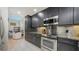 This kitchen offers dark cabinets, granite countertops, stainless steel appliances, and tile flooring at 1921 Monte Carlo Dr # 302, Sarasota, FL 34231