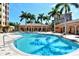 Luxurious outdoor pool area surrounded by lounge chairs, tables, and manicured landscaping, perfect for relaxation and social gatherings at 1921 Monte Carlo Dr # 302, Sarasota, FL 34231