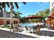 Relaxing poolside retreat with lounge chairs, umbrellas, and lush greenery, with residential buildings in the background at 1921 Monte Carlo Dr # 302, Sarasota, FL 34231