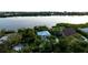 Beautiful waterfront home featuring a metal roof and mature tropical landscaping, nestled amidst lush greenery at 2048 Larson St, Englewood, FL 34223