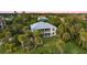 This home features a large backyard with mature palms and lush landscaping, providing shade and privacy at 2048 Larson St, Englewood, FL 34223