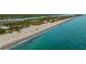 Aerial view of a vibrant beach with people enjoying the sun and surf, showcasing the beautiful coastal scenery at 2048 Larson St, Englewood, FL 34223
