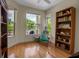 Inviting bedroom featuring a large window with a view of the lush landscaping, complemented by hardwood floors at 2048 Larson St, Englewood, FL 34223