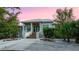 Charming one-story home with a gray metal roof, covered porch, manicured landscaping, and a wide driveway at 2048 Larson St, Englewood, FL 34223