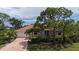 Inviting home with a red tile roof, lush landscaping and a brick driveway at 205 Sugarloaf Dr, Nokomis, FL 34275