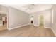 Serene main bedroom with light wood floors, a ceiling fan, and multiple doorways leading to the en-suite bathroom and closet at 205 Sugarloaf Dr, Nokomis, FL 34275