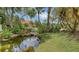 Tranquil backyard features a pond with a bridge leading to a cozy bench, great for relaxing at 205 Sugarloaf Dr, Nokomis, FL 34275
