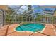 Beautifully designed pool and spa enclosed in a screened lanai, surrounded by lush landscaping at 205 Sugarloaf Dr, Nokomis, FL 34275