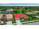Aerial view of a landscaped home with a red roof, surrounded by mature trees at 2148 Date Palm Way, Venice, FL 34292