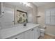 Neutral bathroom featuring a wide mirror, white cabinets, and a shower-tub combination at 2148 Date Palm Way, Venice, FL 34292