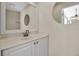 Half bathroom featuring updated single sink vanity with white cabinets and neutral paint at 2148 Date Palm Way, Venice, FL 34292