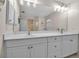Bright bathroom with double sinks, white cabinets, and a large mirror at 2148 Date Palm Way, Venice, FL 34292