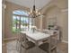 Bright dining room with modern chandelier and a large window overlooking the lush yard at 2148 Date Palm Way, Venice, FL 34292